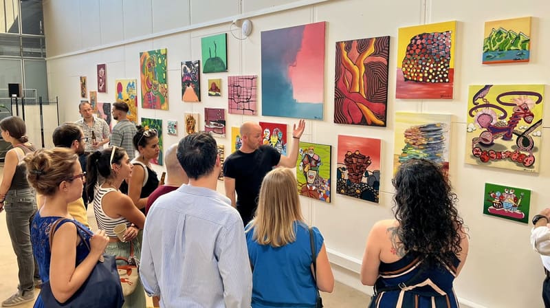 Johan Bavaud zeigt Besucherinnen und Besuchern seine farbigen Bilder an der Vernissage von «Substance», 2023